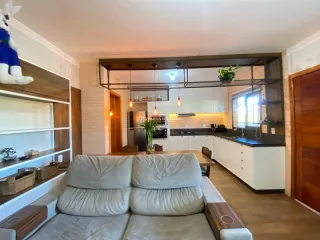 Foto de uma sala de estar com sofá e área de cozinha visível.