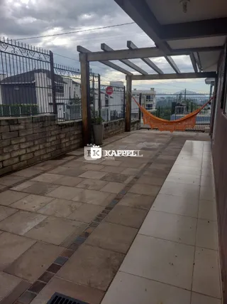 Piso de concreto de uma área externa coberta com estrutura de madeira.