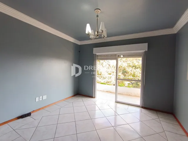 Uma sala de estar com paredes cinzas e piso claro.
