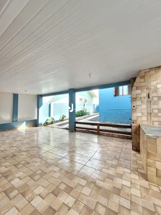 Área interna com piso de cerâmica e vista para o exterior.