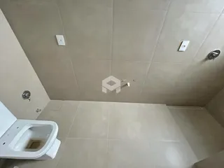 A foto mostra o interior de um banheiro com revestimento de cerâmica.