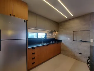 Vista da cozinha de um imóvel em Lajeado, Brasil, com armários de madeira e bancadas escuras.