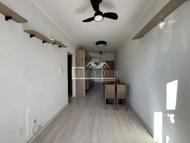 Corredor interno de uma residência com piso de madeira clara.