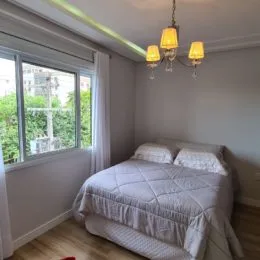 Quarto com cama de casal e janela.