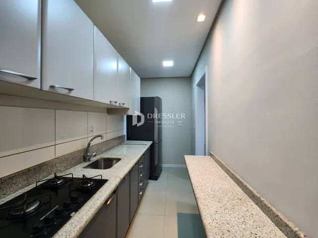 Foto de uma cozinha moderna com armários brancos e bancadas claras.
