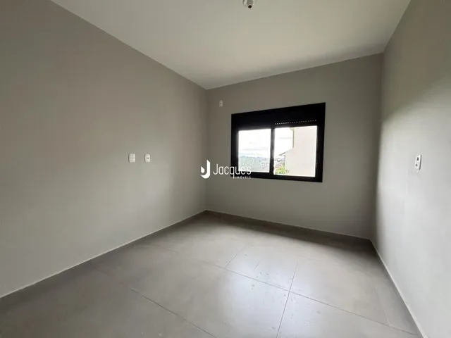 Ambiente interno de uma sala com paredes brancas e piso claro.