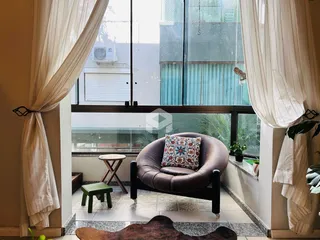 Sala de estar com grandes janelas que dão vista para o exterior.