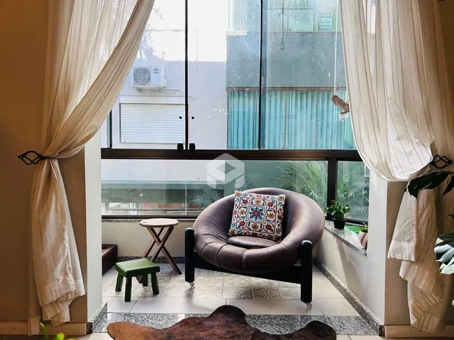 Sala de estar com grandes janelas que dão vista para o exterior.