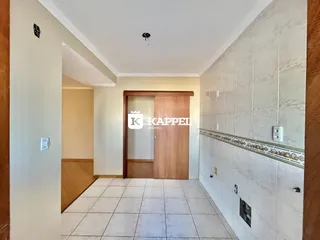 Foto de um corredor interno com piso de cerâmica clara e paredes em tons neutros.