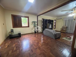 Sala de estar com piso de madeira e janela em um imóvel no Brasil.