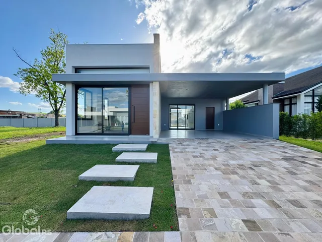 Fachada moderna de uma residência em Lajeado, Brasil, com jardim e área de concreto.