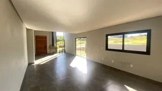 Sala ampla com piso de cerâmica e grande janela voltada para o exterior.