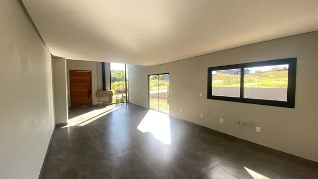 Sala ampla com piso de cerâmica e grande janela voltada para o exterior.