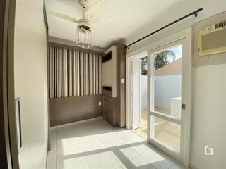 Hall de entrada com piso claro e painel de madeira na parede.