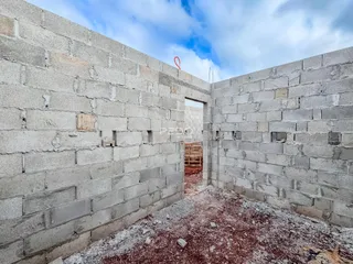 Interior de uma estrutura com paredes de bloco de concreto aparente.
