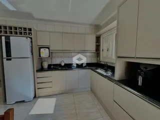 Foto de uma cozinha com armários e bancadas em tons neutros.