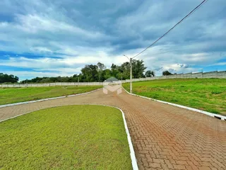 Vista externa de uma propriedade com paisagem verde e estrada de acesso.