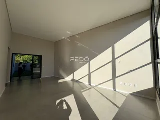Ambiente interno de uma sala ampla com piso claro e luz natural.