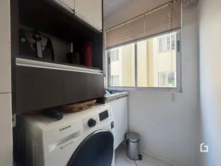 Foto de um interior mostrando armários e uma máquina de lavar roupa.