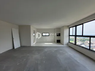 Espaço interno vazio com piso de concreto e grande janela.