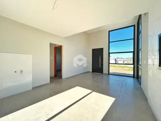 Ambiente interno amplo com piso de cerâmica e porta de vidro em uma residência em Lajeado.