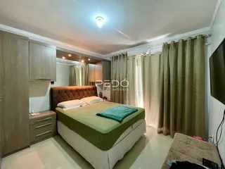 Quarto com cabeceira de couro e armários em madeira clara.