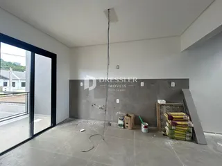 Ambiente interno de uma sala em construção com piso de concreto.