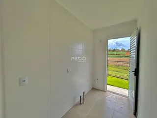 Interior de um corredor com vista para o campo verde ao ar livre.
