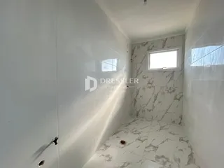 Foto de um banheiro com revestimento branco e piso de mármore na Lajeado.
