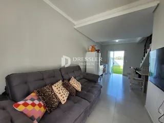 Sala de estar com sofá cinza e almofadas decorativas.