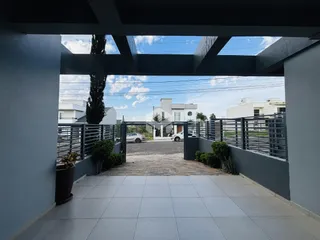 Vista da entrada de uma propriedade em Lajeado, Brasil, com cerca e paisagismo.