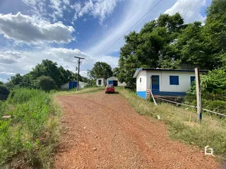 Vista da propriedade rural em Lajeado, Brasil, com estrada de terra e vegetação ao redor.
