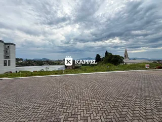 Vista externa de um edifício moderno com paisagem rural ao fundo.