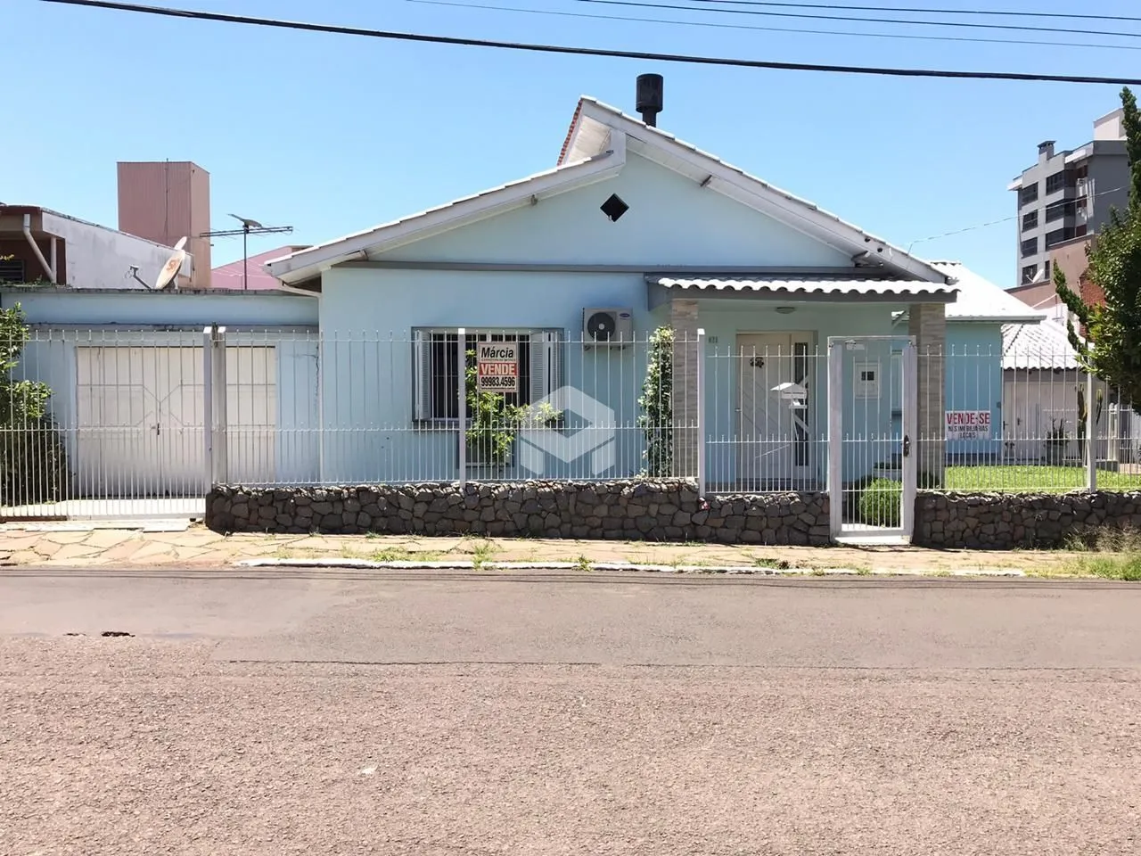 Fachada de uma residência em Lajeado, Brasil, com cerca e portão de ferro.