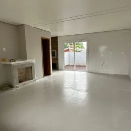 Sala ampla com piso claro e lareira visível na parede.