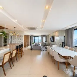 Sala de estar ampla com piso claro e sofá visível.