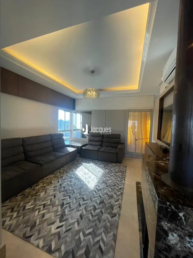 Sala de estar com sofá e tapete no interior de uma residência.