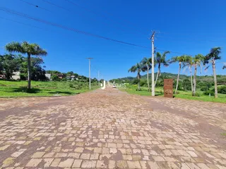 Vista da entrada de uma propriedade em Lajeado, Brasil, com paisagem verde.