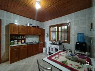 Cozinha com armários de madeira e piso de cerâmica em Lajeado.