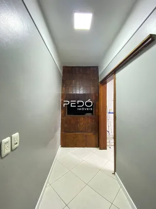 Corredor interno de uma residência com piso de cerâmica e paredes brancas.