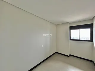 Ambiente interno de uma sala com paredes brancas e piso claro.