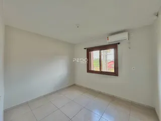 Ambiente interno de uma sala com piso de cerâmica e janela.