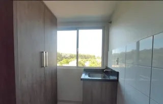 Uma área com bancada e janela em um imóvel.