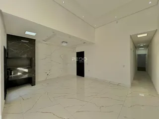 Hall de entrada com piso de mármore claro e paredes brancas.