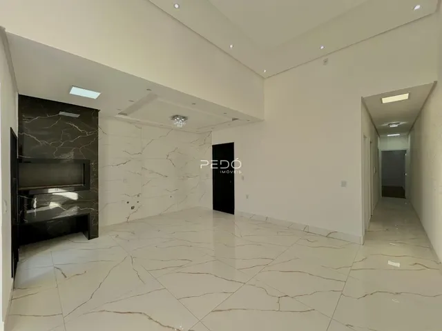 Hall de entrada com piso de mármore claro e paredes brancas.