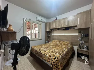 Quarto com cabeceira de madeira e armários em Lajeado, Brasil.