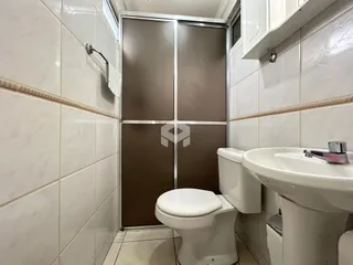 Foto do interior de um banheiro com revestimento de azulejos brancos.