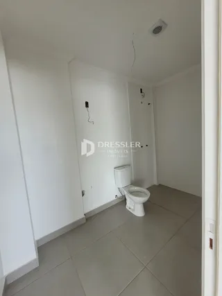 Quarto interno com vaso sanitário branco e piso claro.