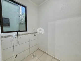 Vista interna de um cômodo com parede branca e piso de cerâmica.