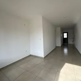 Corredor interno com paredes brancas e piso de cerâmica.